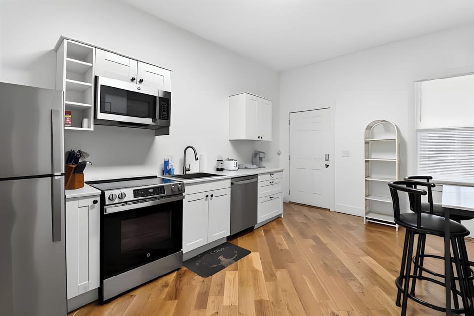 Cook up a storm in our bright kitchen packed with shiny stainless steel appliances. You can enjoy your morning coffee right at the black counter stools.