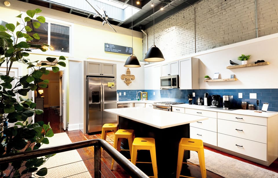 Gather your group around the massive gleaming island for drinks and appetizers. The bright yellow stools add such a happy pop of color against the dark floors.