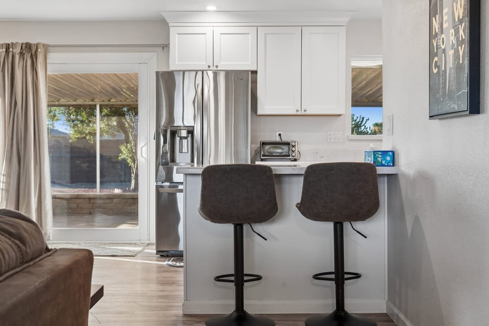 Stainless steel appliances, wine fridge, counter seating for 2, and cooking essentials.