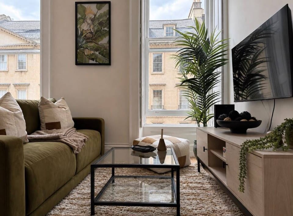 The living room features a cosy sofa and a smart TV for entertainment