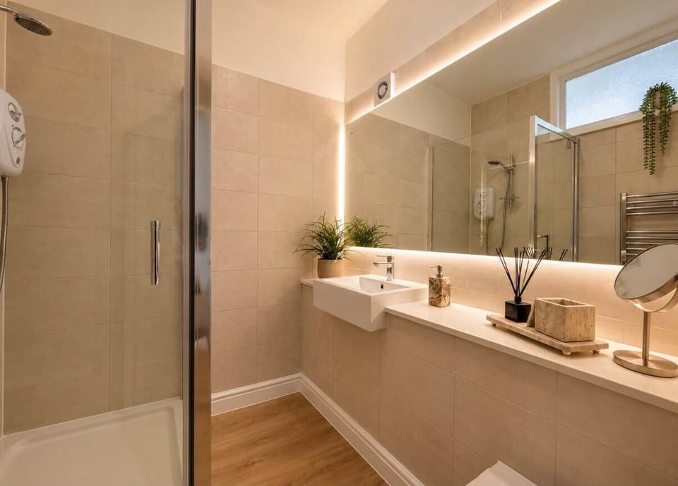 The bathroom features a toilet, a sink, and an electric shower