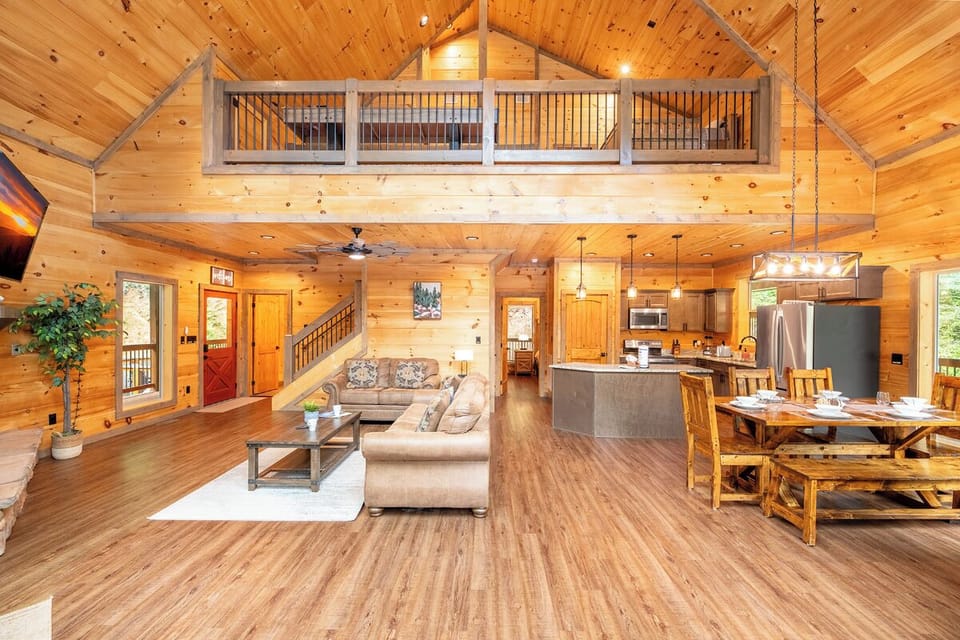 Warm wood and soaring ceilings create a cozy yet spacious retreat. Relax in the open living area, gather around the dining table, or unwind in the lofted space above.