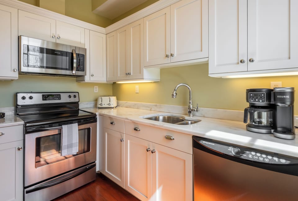Elegant kitchen, fully stocked with white cabinets and essential appliances.