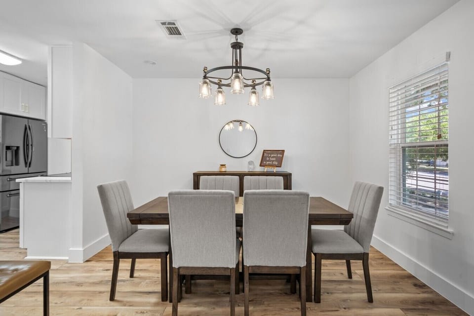 Share meals at the dining table for six, framed by a chandelier and open to the kitchen.