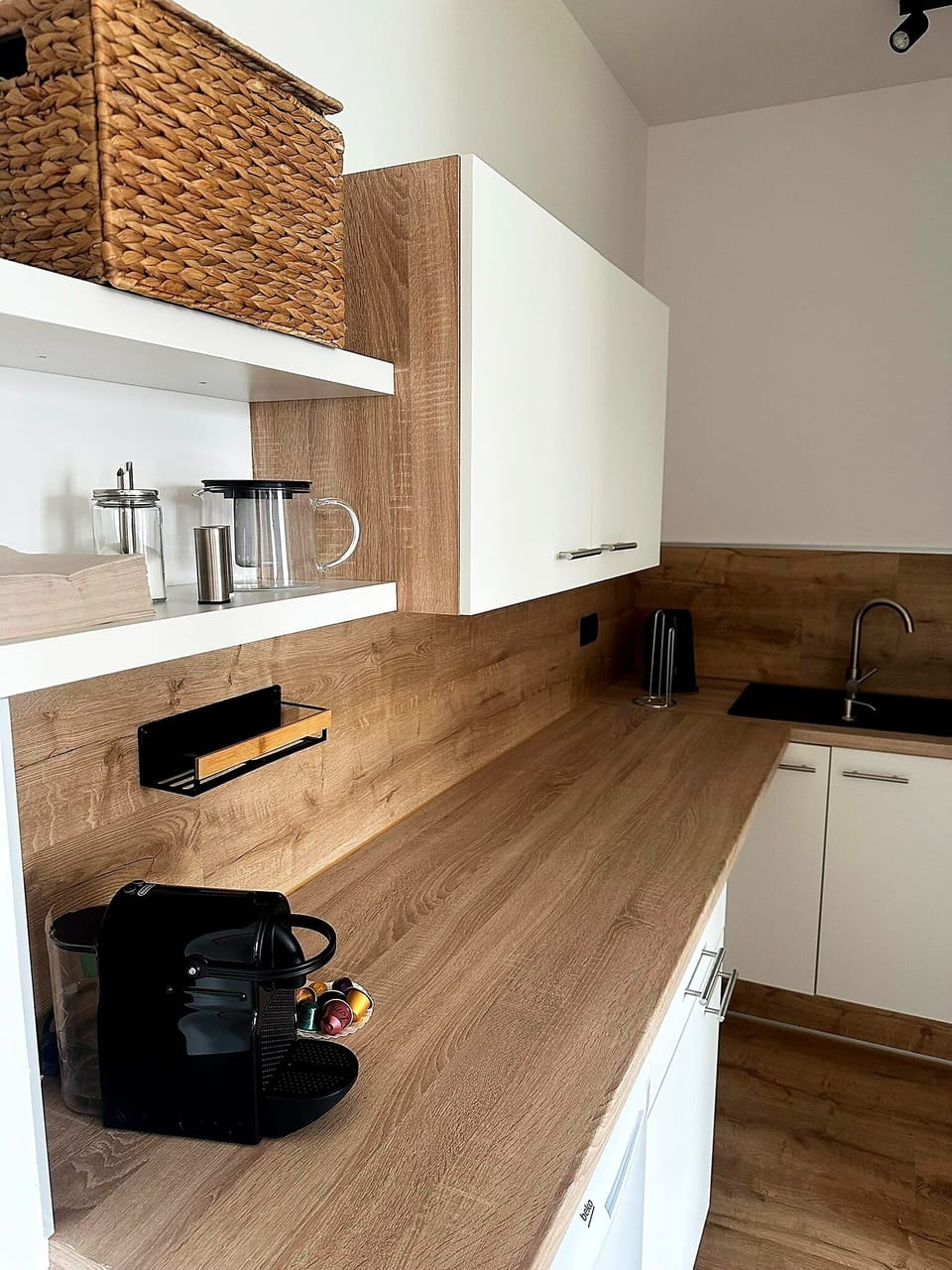 Modern kitchenette with coffee machine and warm wood finishes