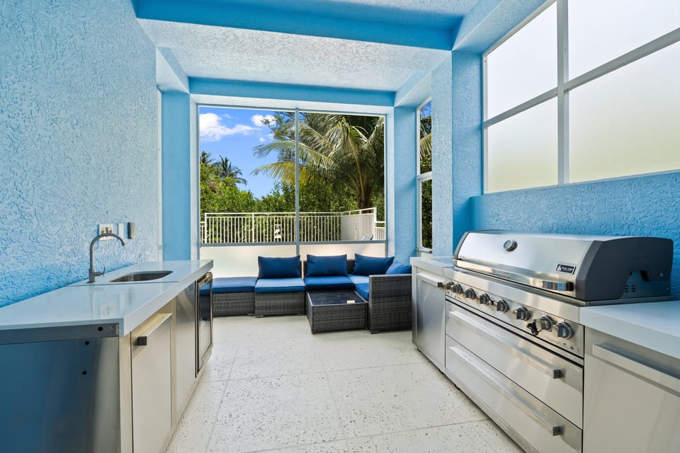 Enjoy the outdoor kitchen while overlooking the pool activities.