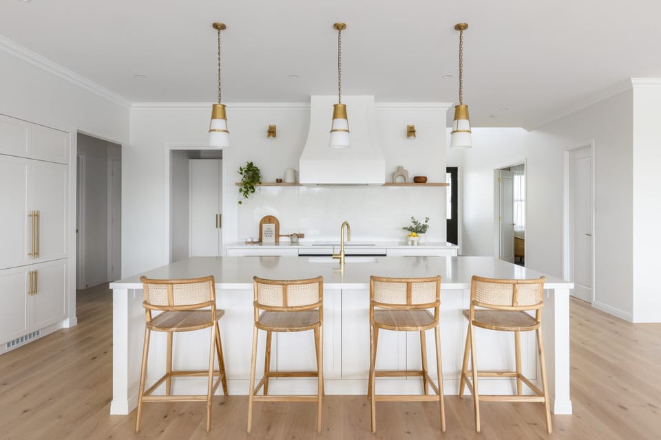 Rattan stools line the island under pendant lighting