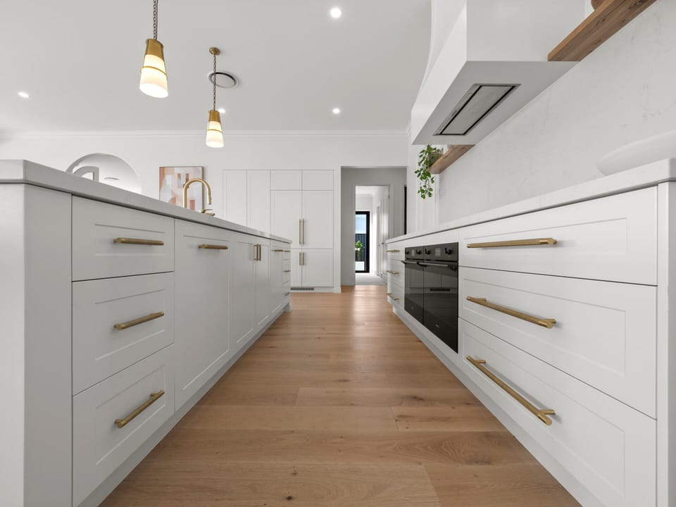 The working side of the kitchen: built-in oven and stone benchtops