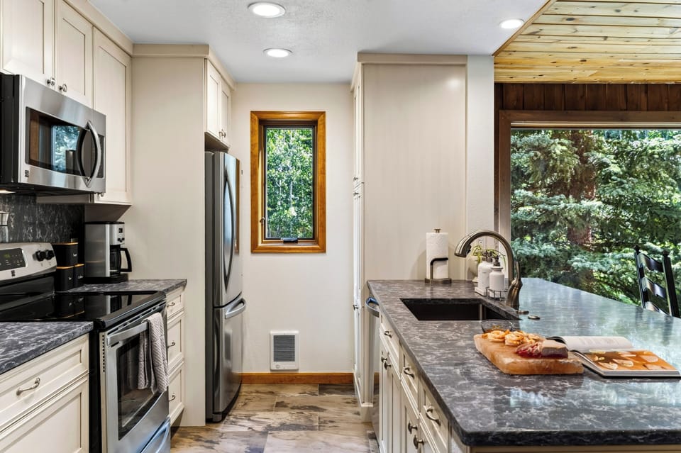 Prepare meals in the fully equipped kitchen, featuring stainless steel appliances and generous counter space.