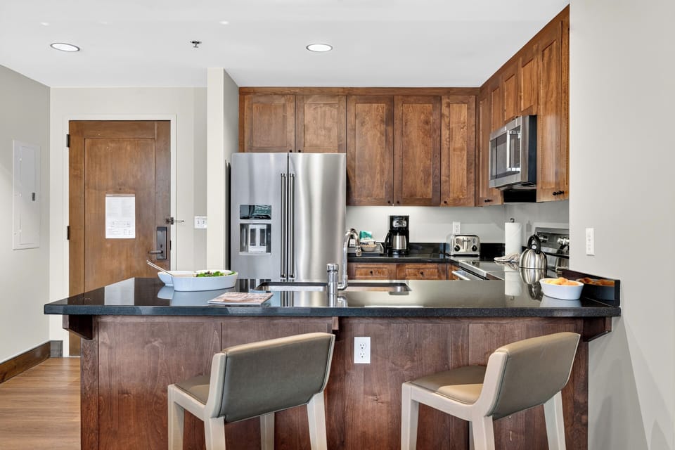 A well-equipped kitchen features stainless steel appliances, generous cabinetry, and counter seating for casual breakfasts or quick bites.