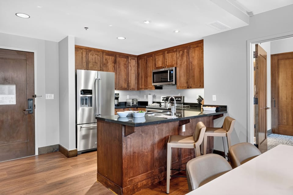 A well-equipped kitchen features stainless steel appliances, generous cabinetry, and counter seating for casual breakfasts or quick bites.