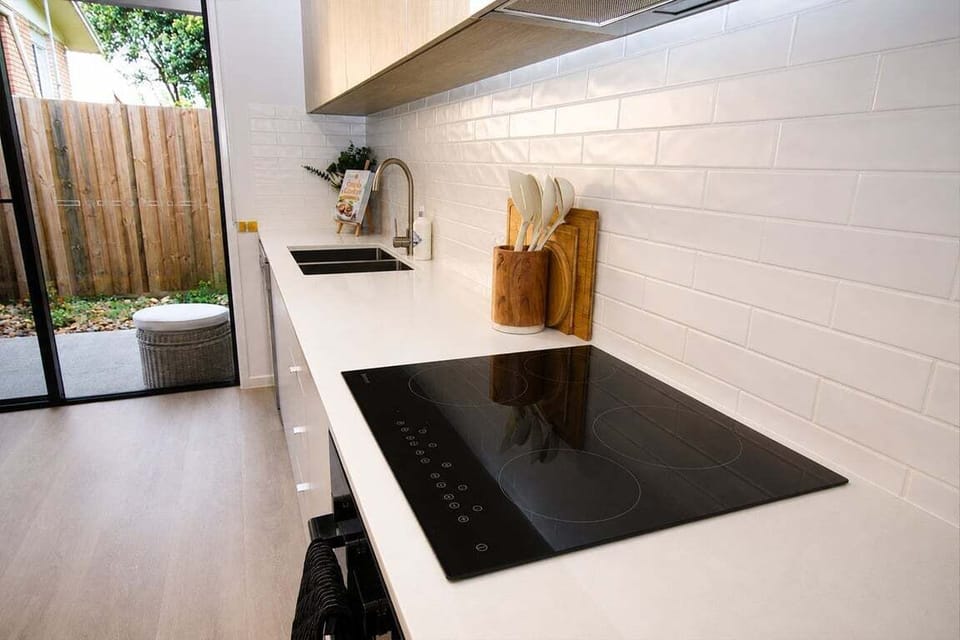 Kitchen – generous bench space with electric cooktop, oven & easy access to the outdoor area.