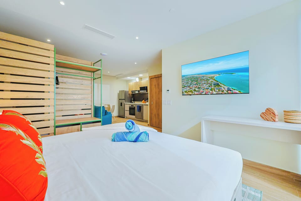 Enjoy restful nights in this bright, modern sleeping area featuring a comfortable king-size bed, soft linens, a Smart TV with IPTV channels, and a clean, contemporary design for a relaxing stay.