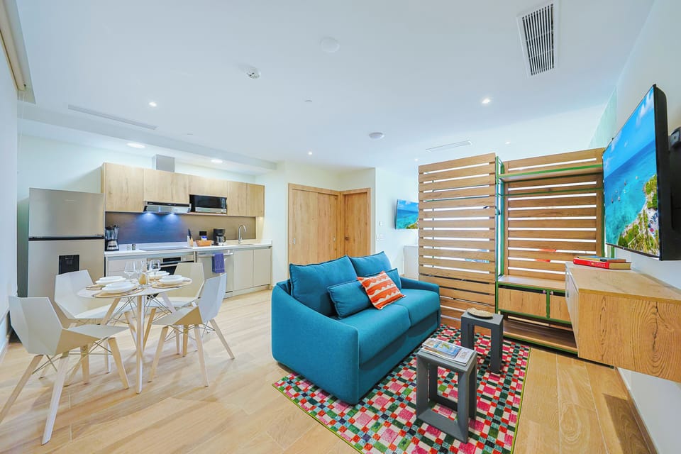 Your bright, open-plan space blends style and comfort with cheerful blue furnishings, warm wood finishes, and a fully equipped kitchen ready for your stay.