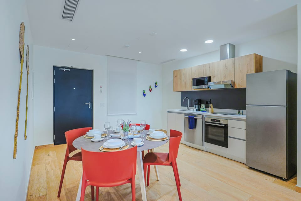 Your bright, modern kitchen and dining space features sleek appliances, warm wood cabinetry, and a welcoming table ready for shared meals and memories.