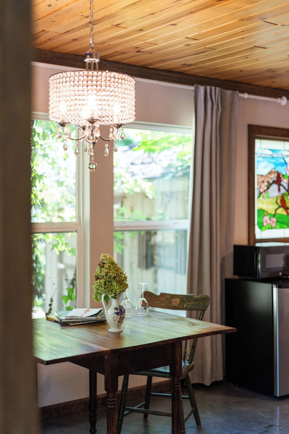 Sunny dining nook with crystal chandelier and garden-view windows