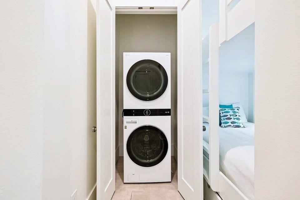 High-capacity front-load stackable washer and dryer unit on the main lower level.