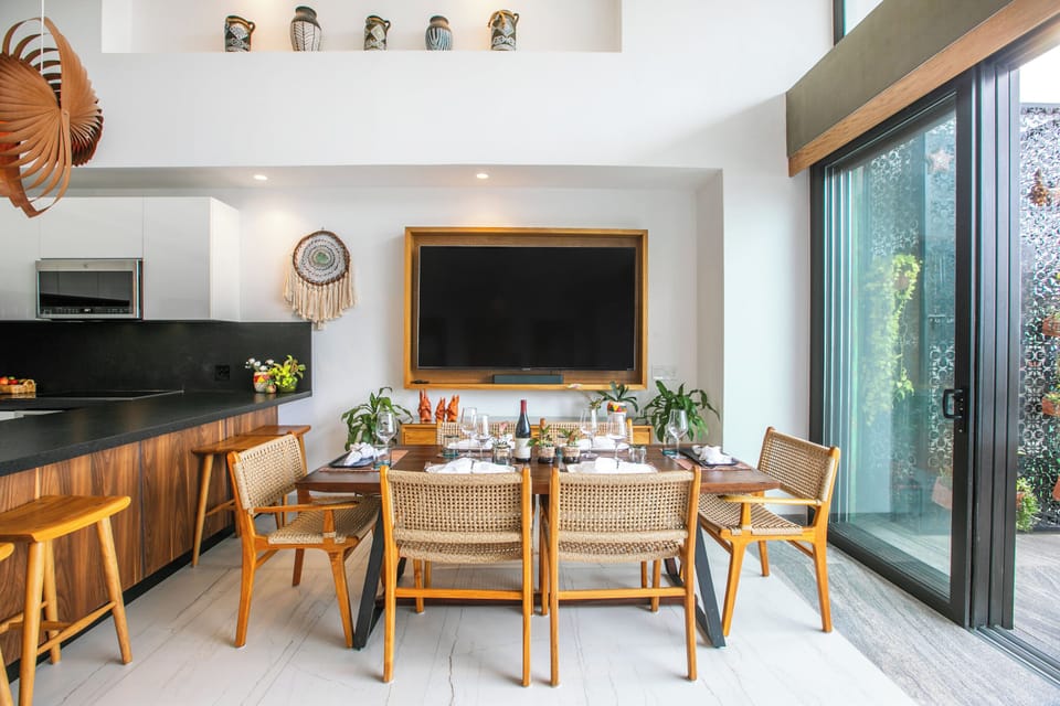Gather around the handsome wooden dining table for meals and conversation in this light-filled open space, where modern design meets warm and natural touches