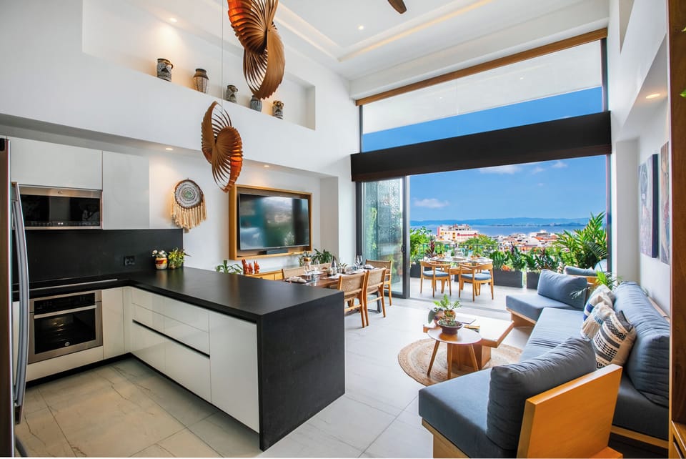 Bright, open-concept living space where the kitchen flows seamlessly into the living and dining areas. Beyond the terrace, stunning ocean views frame your perfect getaway