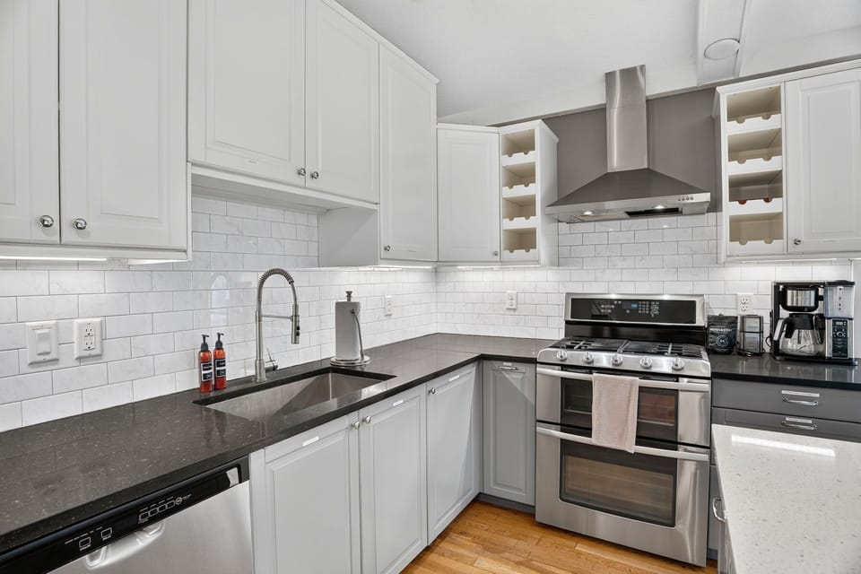 Your kitchen awaits with sleek stainless appliances, granite counters, and a wine rack ready to hold your favorites—perfect for preparing a home-cooked meal.