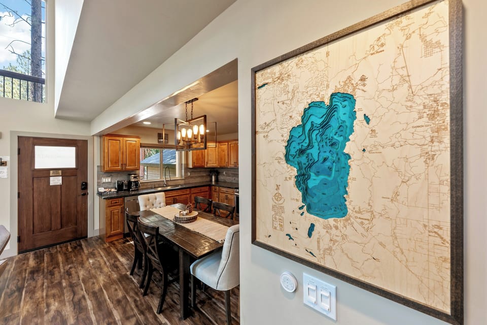Step inside to discover a warm, open-concept space where the kitchen flows seamlessly into the dining area. Sunlight pours through tall windows and skylights, illuminating rich wood cabinetry and gleaming countertops.
