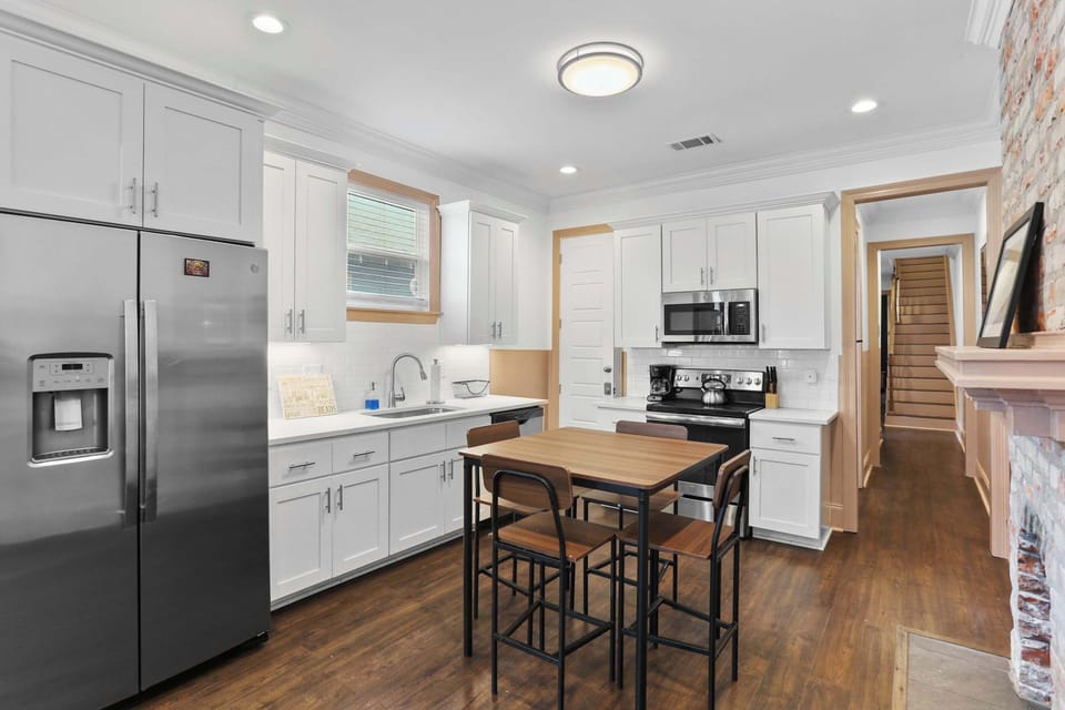 Bright kitchen with stainless steel appliances, generous counter space, and a dining table with seating for four.