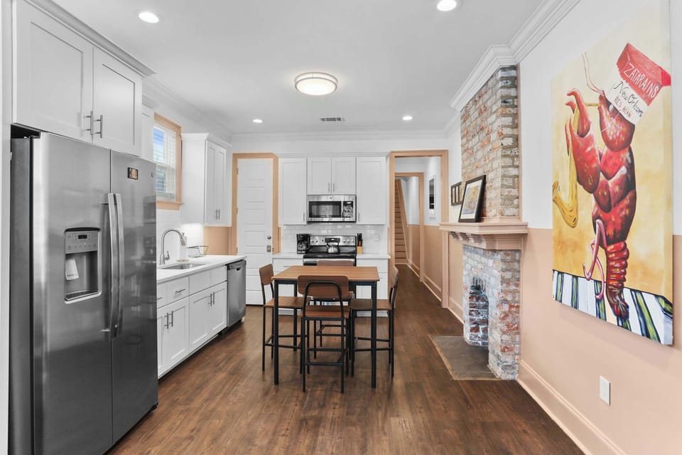 Fully equipped kitchen with stainless steel appliances, ample cabinetry, and a dining table for enjoying meals together.