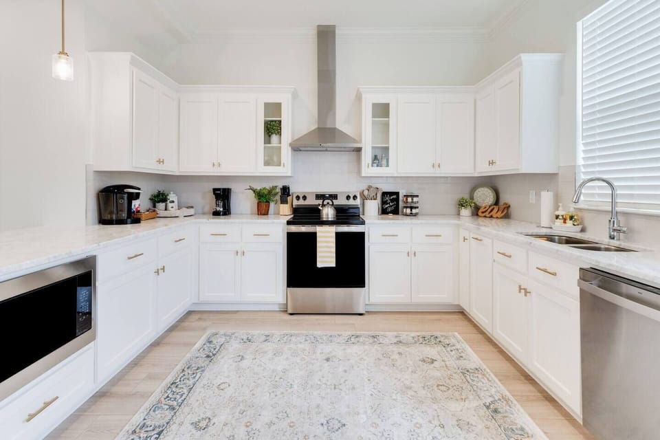Fully stocked kitchen with stainless steel appliances, coffee, sugar, creamer, and a few snacks.