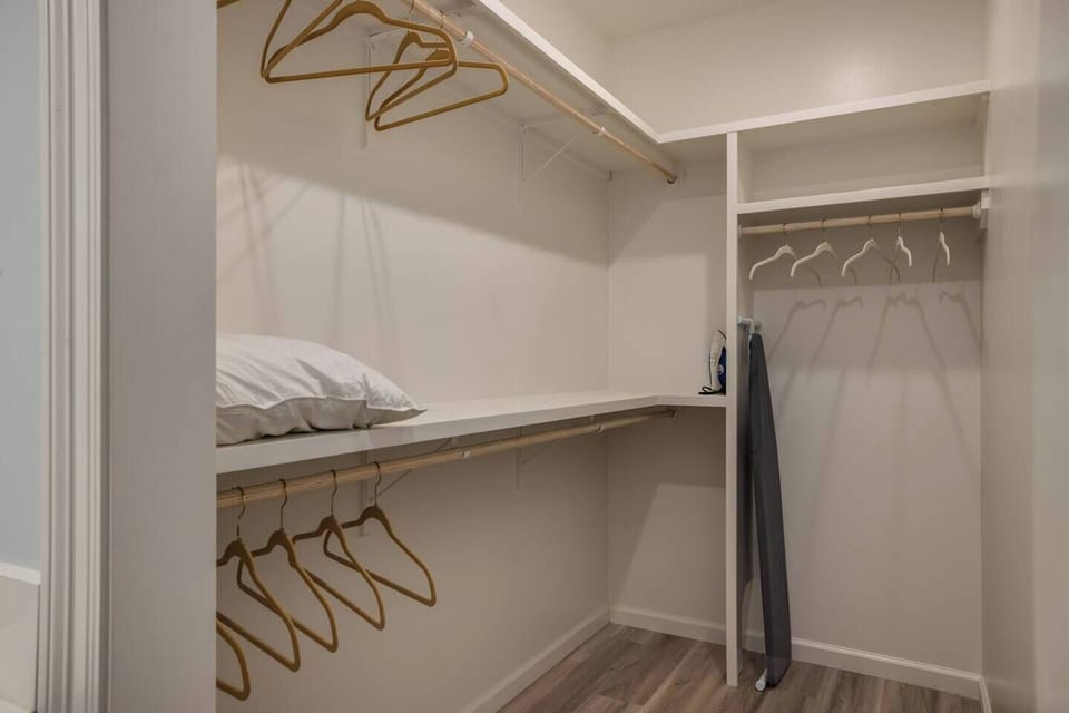 Vermilion Sanctuary master walk-in closet with iron, ironing board and extra pillows