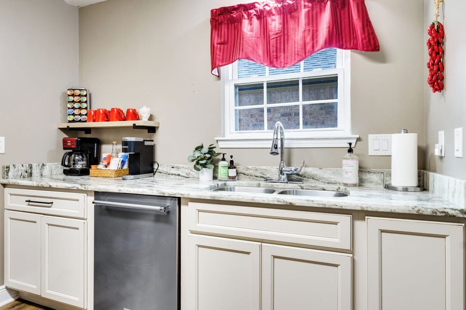 Bright coffee bar with mini fridge, double sink, and marble-look counters