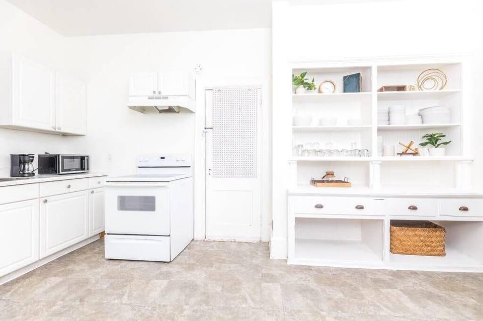 Bright white kitchen with open shelving and plenty of prep space