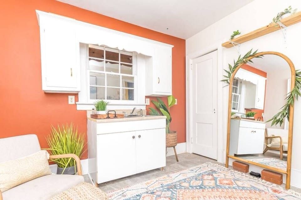 Bright, stylish vanity space with bold accents, mirror, and cozy decor