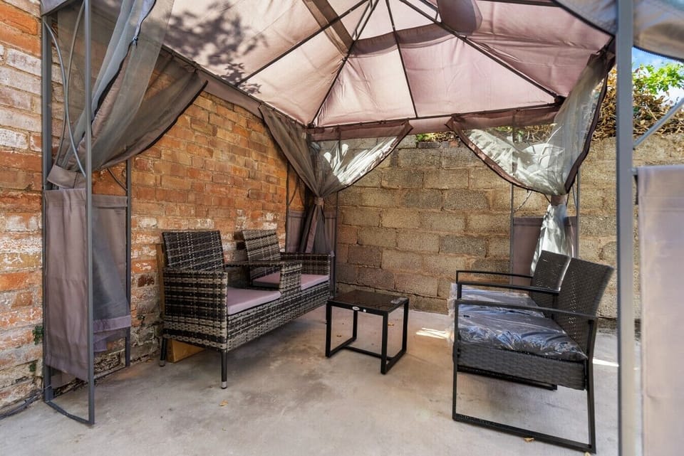 Take a moment to relax in the garden seating area, with a cosy outdoor setup for enjoying some fresh air.