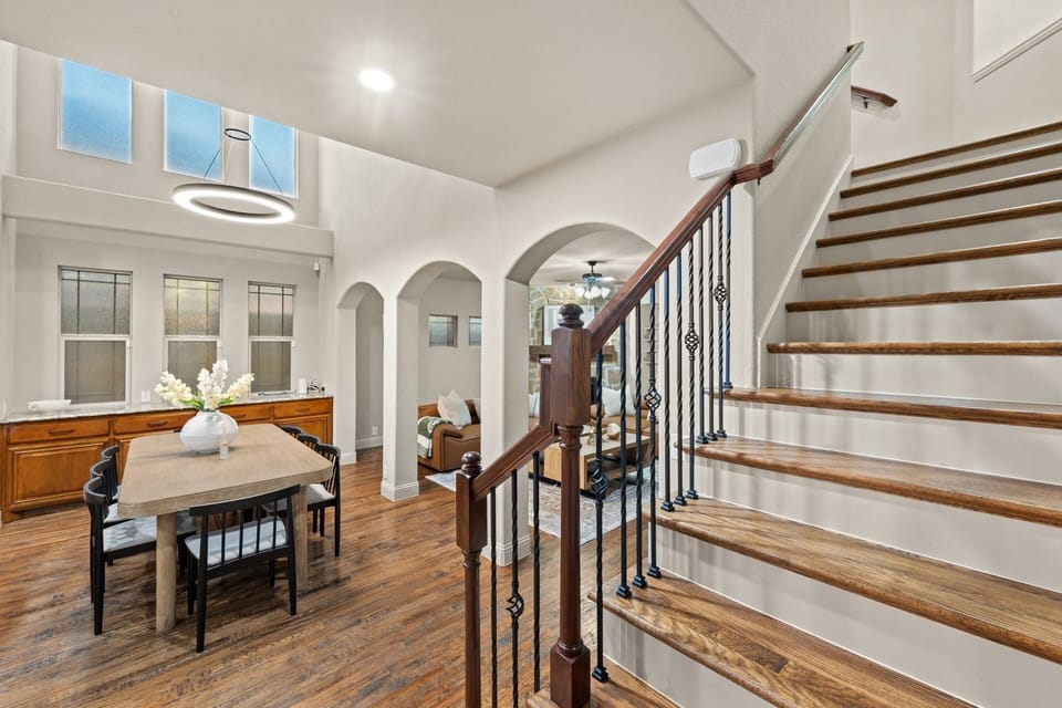 Take in the bright, open entry where soaring ceilings and an elegant wrought-iron staircase set a warm first impression.