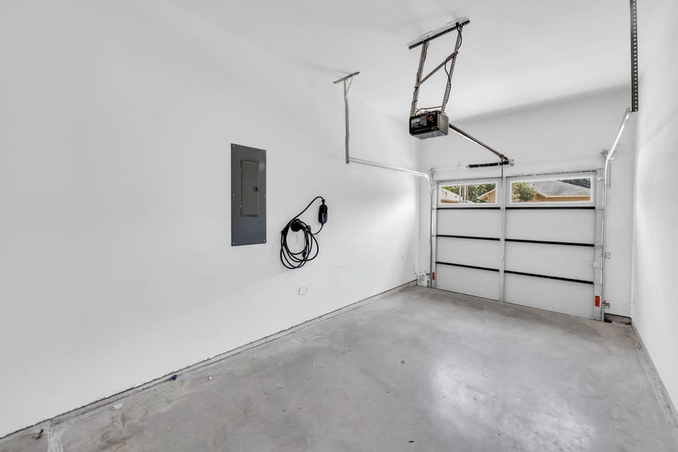 Clean private garage with automatic door and EV charging outlet