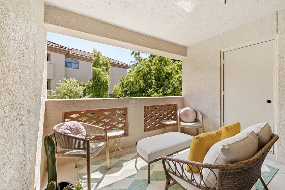 Shaded private patio with cozy seating and leafy, tranquil views