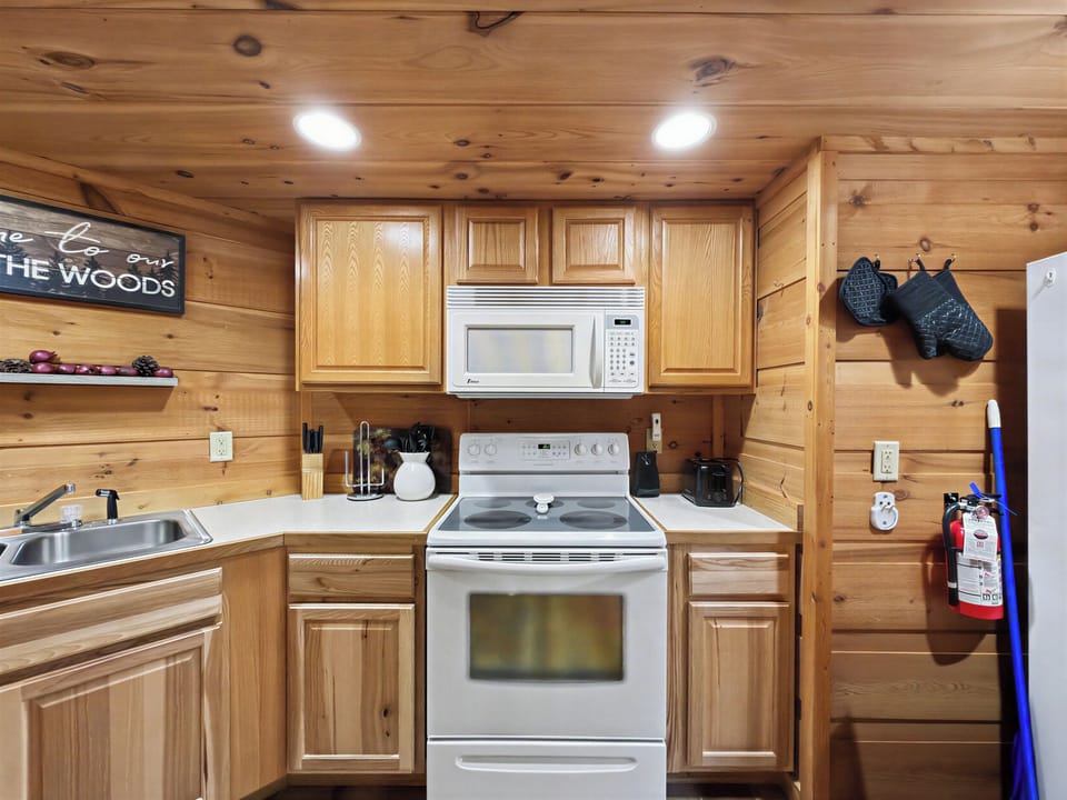 Cozy wood-lined cabin kitchen with full appliances and rustic charm