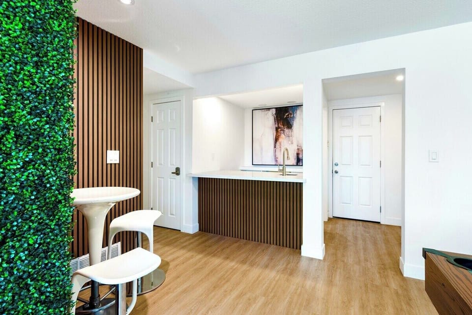 Modern wet bar with sleek wood-slat detailing, and a stylish bistro seating area.