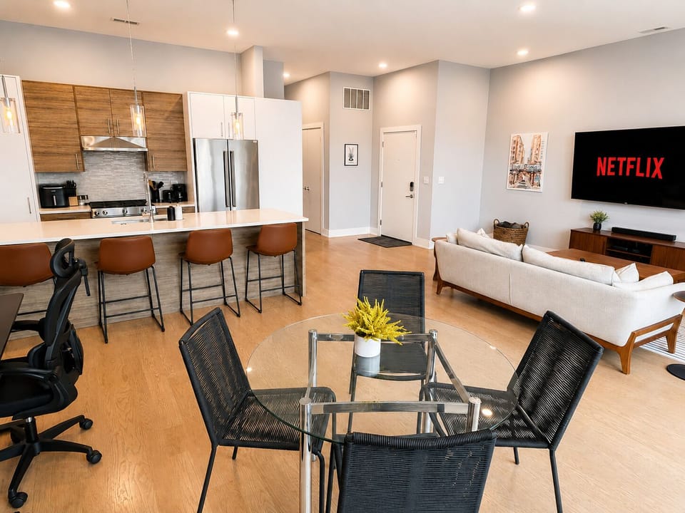 Bright open-concept living with island seating, dining space & large TV