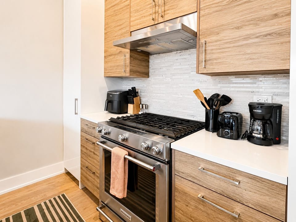 Modern kitchen with gas range, sleek finishes, and fully stocked essentials
