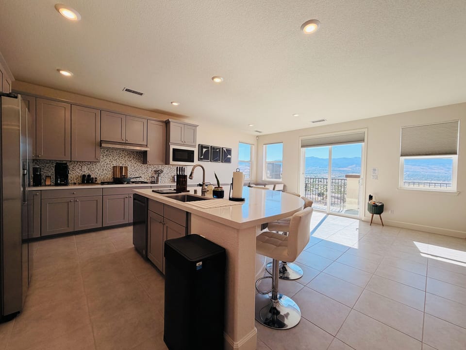 Dine with a view. This inviting dinning space features comfortable booth seating, modern mid-century chairs, and large windows showcasing stunning scenic vistas. The perfect sun-drenched spot to enjoy breakfast or a family dinner.