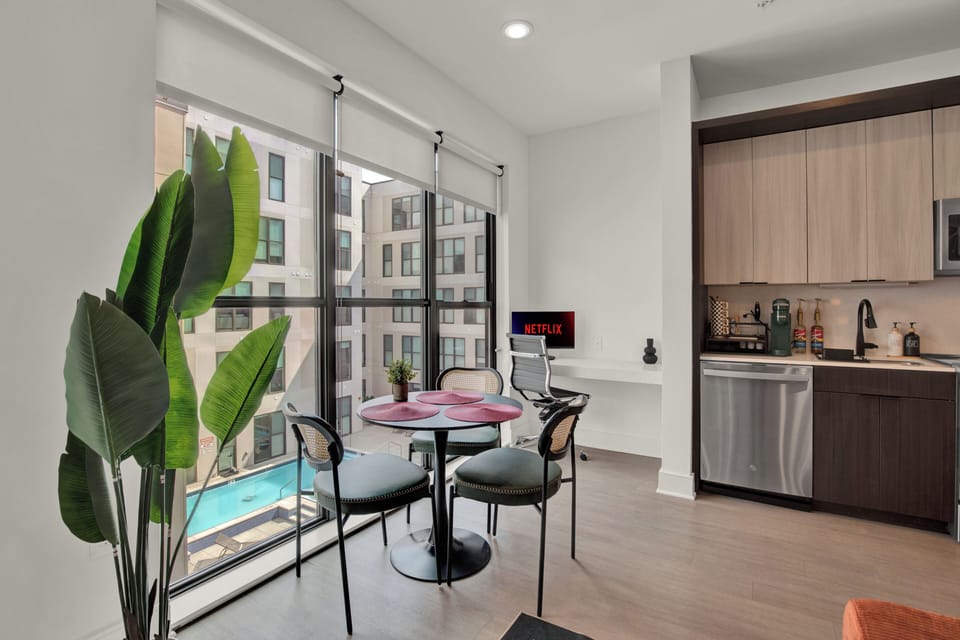 Bright dining nook with pool views, workspace, and modern kitchenette