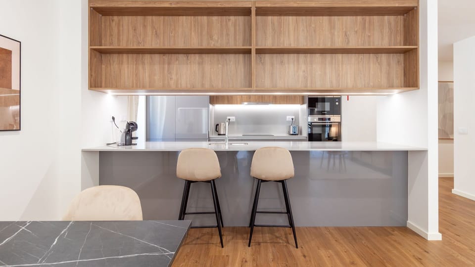 The fully equipped, open-plan kitchen invites culinary adventures with its sleek design, integrated appliances, and generous counter space, featuring a breakfast bar perfect for morning coffee or casual meals. Enjoy effortless cooking and a social atmosph