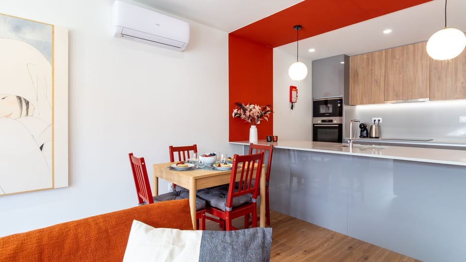This inviting open-plan space seamlessly blends a modern kitchen with a cozy dining area, perfect for enjoying meals and conversation in a vibrant setting. The bright, stylish design and comfortable seating make it ideal for relaxing after a day of explor