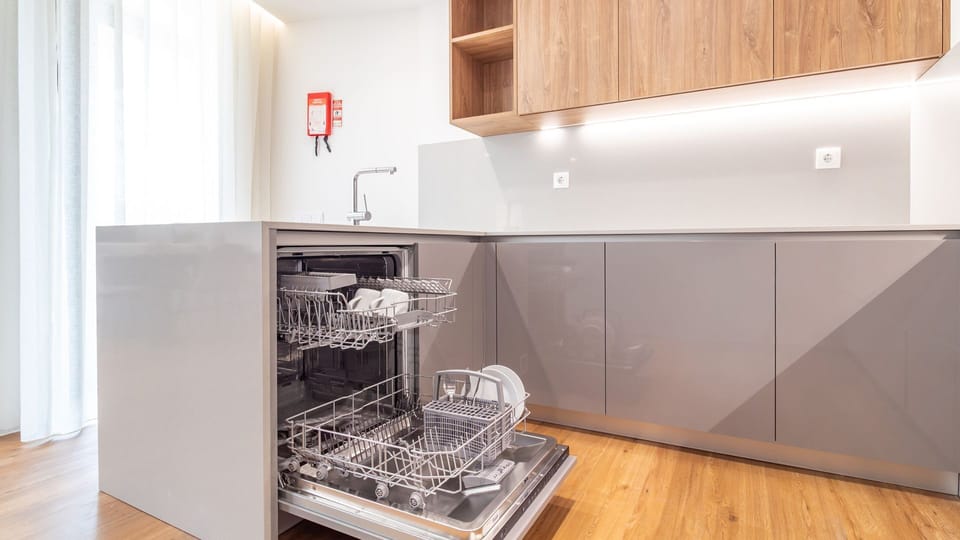 Whip up your favorite dishes in this fully equipped, contemporary kitchen, featuring a convenient dishwasher and modern appliances for a hassle-free stay. The thoughtful design ensures everything you need is at your fingertips, making meal preparation a b