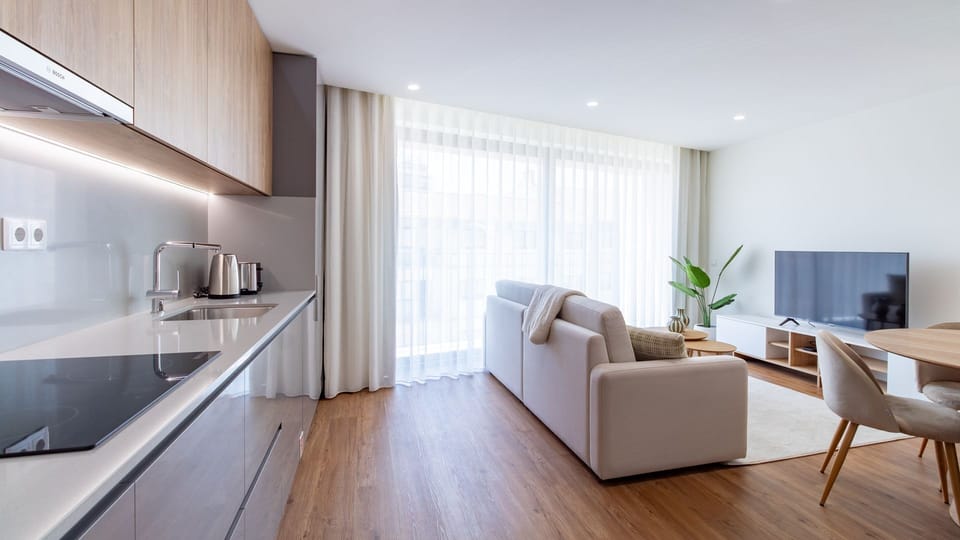 Create culinary delights in the sleek, fully equipped kitchen with integrated appliances and ample counter space, then effortlessly transition to the comfortable living area. Expansive windows ensure the space is always bright and airy, enhancing your sta