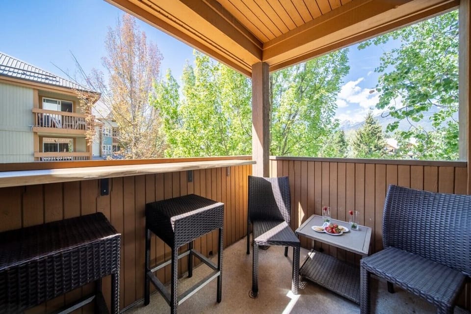 Covered balcony with seating and mountain views.