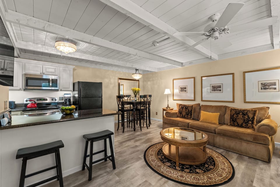 Cozy open-concept living with full kitchen, bar seating, and dining area