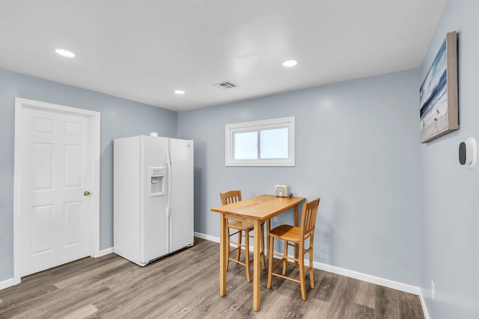 Bright, cozy dining nook with full-size fridge and modern finishes