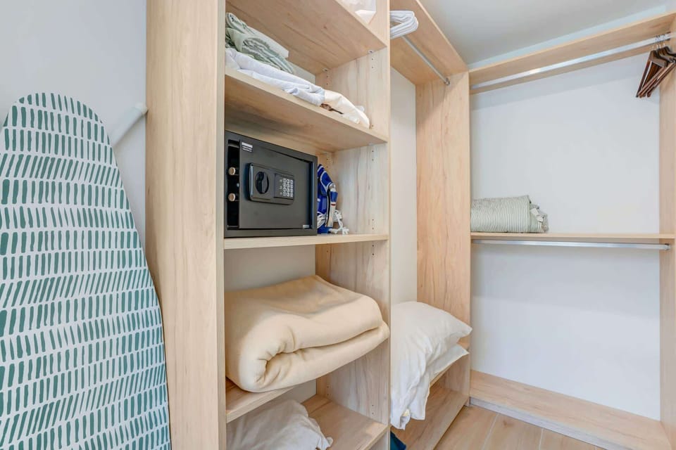 Spacious and organized closet with secure safe and ample storage for a comfortable stay.